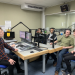 A group of people sat around radio equipment