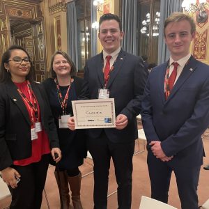 4 people standing together with a certificate