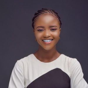 A head shot of international student Olamide, she wears a white and black top and a bright smile.