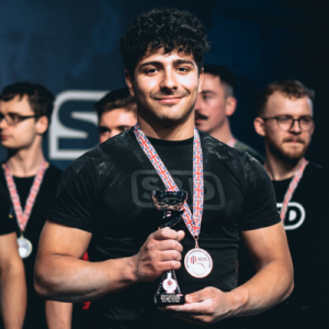 Luca Silva holding a trophy at a powerlifting competition