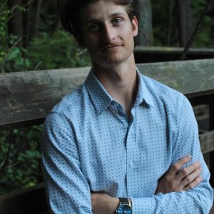 Zechariah Johnson sitting crossed arms smiling at the camera with his arms crossed