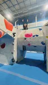 Sitting at the top of a bouldering wall at Bournemouth Climbing Club at The Project Climbing Centre in Poole