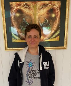 Sarah stands in front of a piece of art 